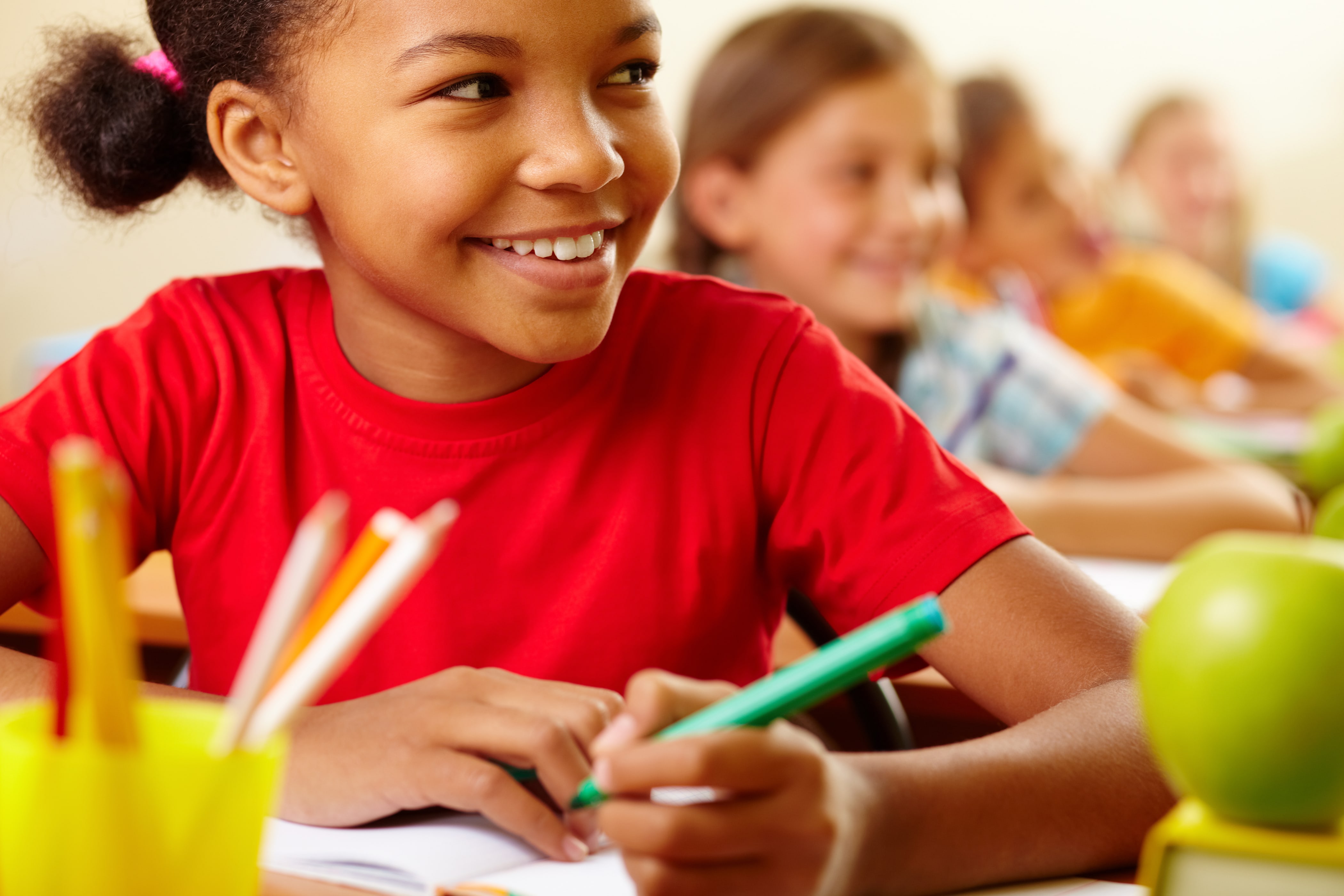girl at school desk smiling